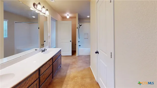 a bathroom with a tub sink and mirror