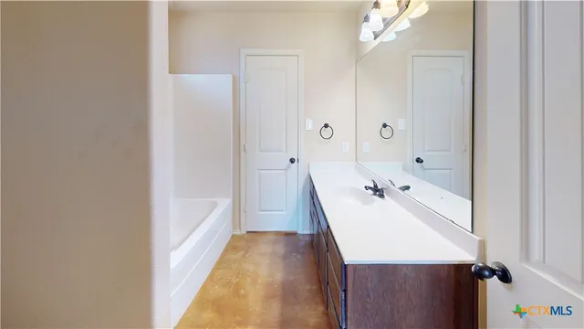 a bathroom with a granite countertop sink and a toilet