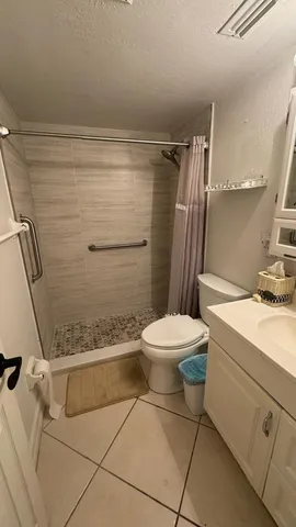 a bathroom with a sink a toilet a mirror and shower