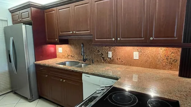 a kitchen with granite countertop cabinets and black appliances