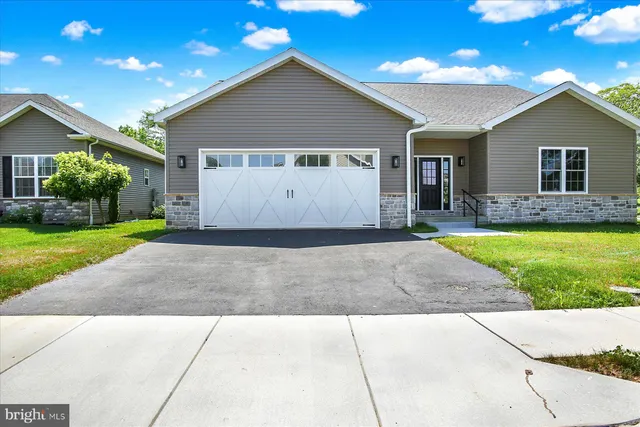 a view of a house with a yard and potted plants