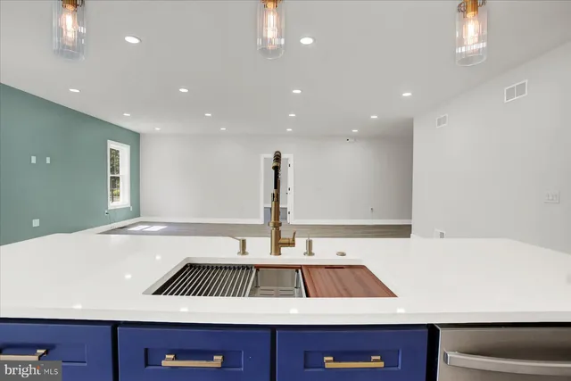 a kitchen with stainless steel appliances granite countertop a sink a stove and a wooden floors