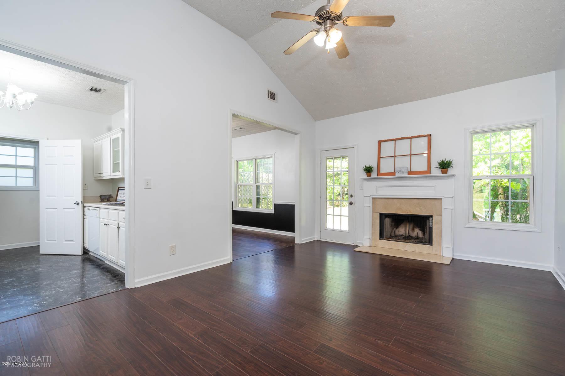101 Hickory Road Jackson, GA 30233 - Photo 4 of 32 an empty room with wooden floor a fireplace and windows