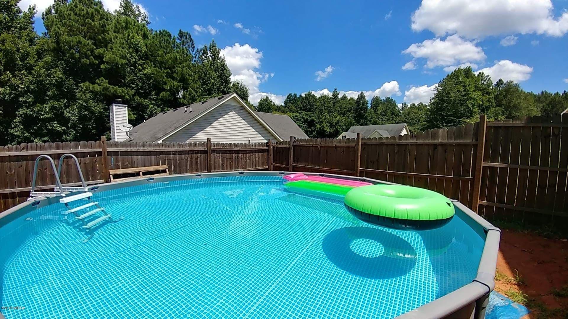 101 Hickory Road Jackson, GA 30233 - Photo 32 of 32 a view of a white house with a swimming pool and a yard