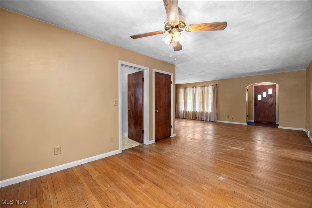 25950 Bagley Road Olmsted Falls, OH 44138 - Photo 5 of 32 Unfurnished living room with arched walkways, light wood-type flooring, and a ceiling fan