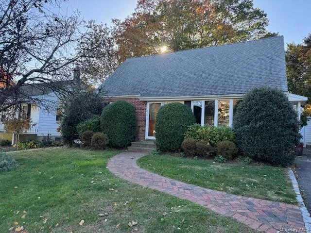 a view of a house with a yard and large trees