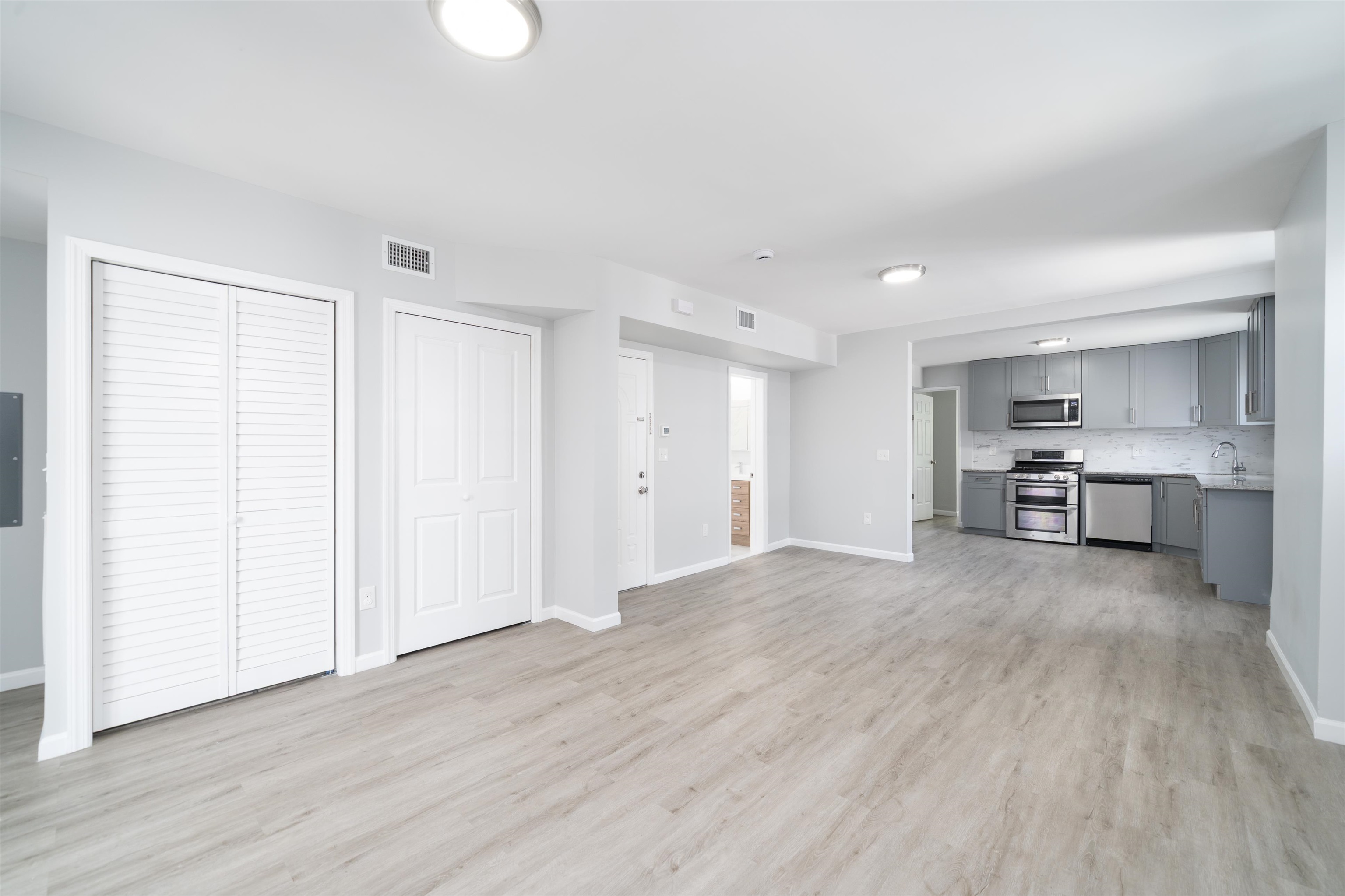 a view of kitchen and hall with wooden floor