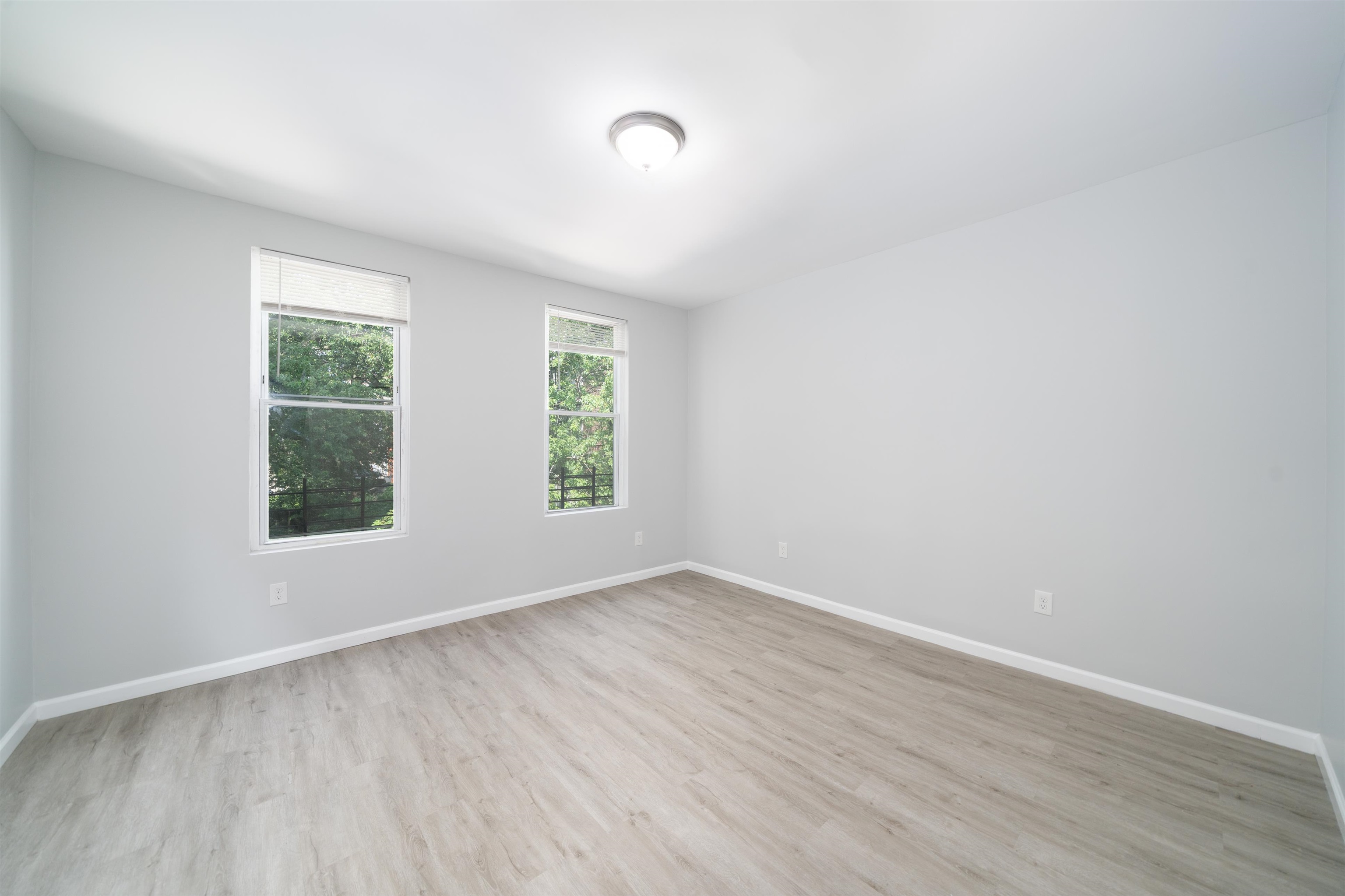 408 Monastery Place, Unit 2 Union City, NJ 07087 - Photo 13 of 21 an empty room with wooden floor and windows