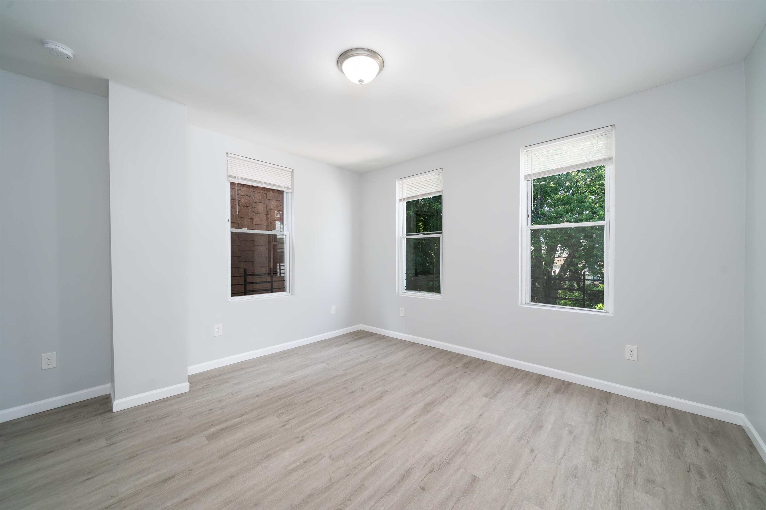 408 Monastery Place, Unit 2 Union City, NJ 07087 - Photo 14 of 21 an empty room with wooden floor and windows