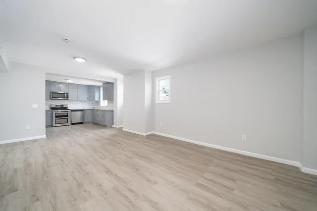 a view of empty room with wooden floor