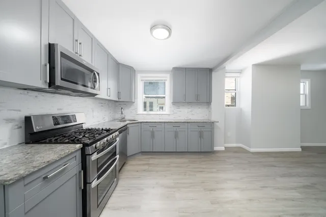 a kitchen with stainless steel appliances granite countertop a stove a microwave and a sink