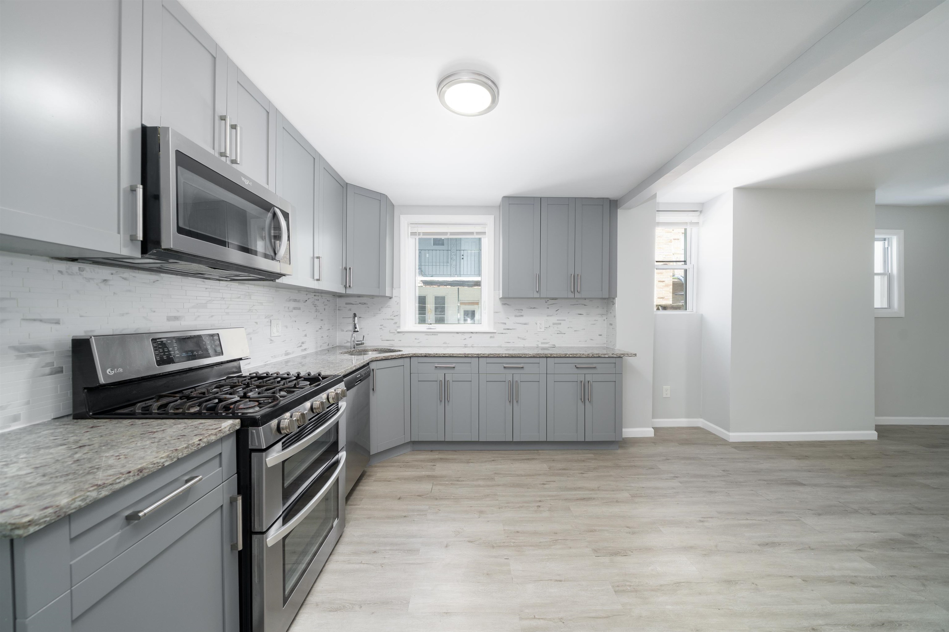 408 Monastery Place, Unit 2 Union City, NJ 07087 - Photo 3 of 21 a kitchen with stainless steel appliances granite countertop a stove a microwave and a sink