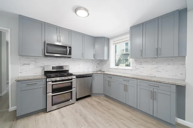 a kitchen with sink a microwave and cabinets