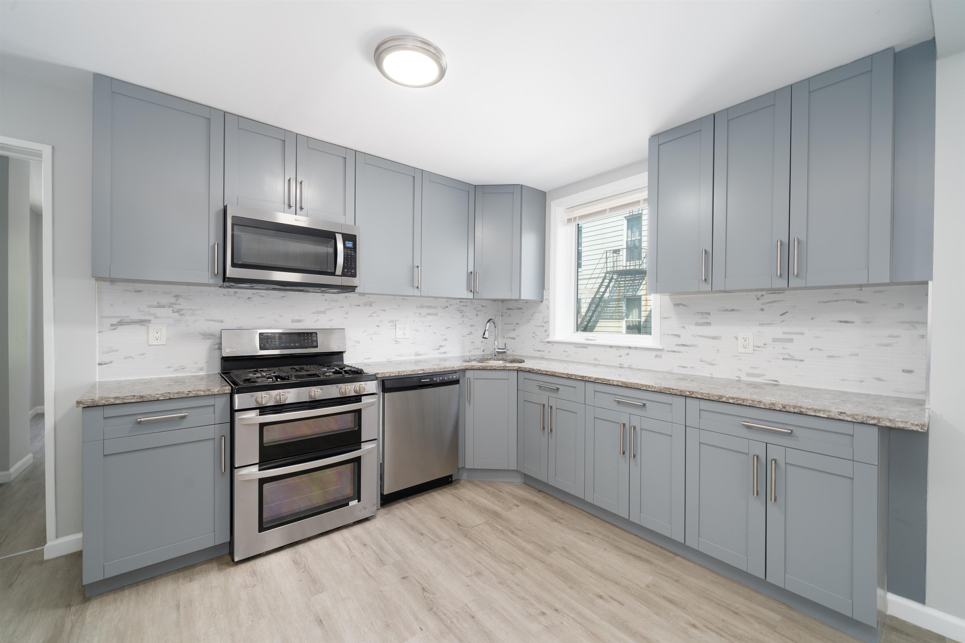 408 Monastery Place, Unit 2 Union City, NJ 07087 - Photo 4 of 21 a kitchen with sink a microwave and cabinets