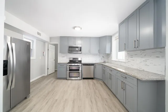 a kitchen with stainless steel appliances a refrigerator sink and cabinets