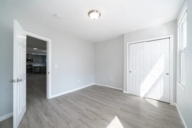 an empty room with wooden floor and closet