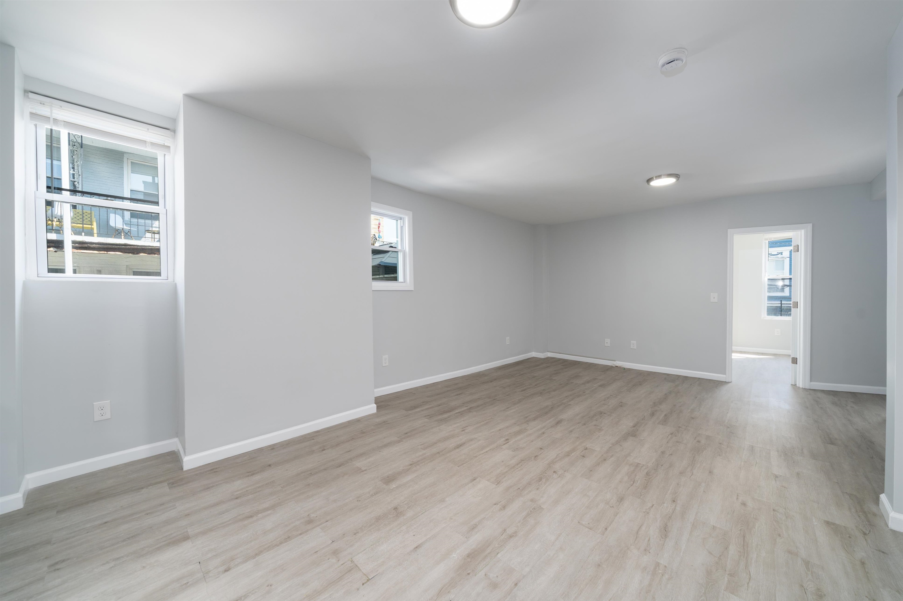 408 Monastery Place, Unit 2 Union City, NJ 07087 - Photo 7 of 21 an empty room with wooden floor and windows