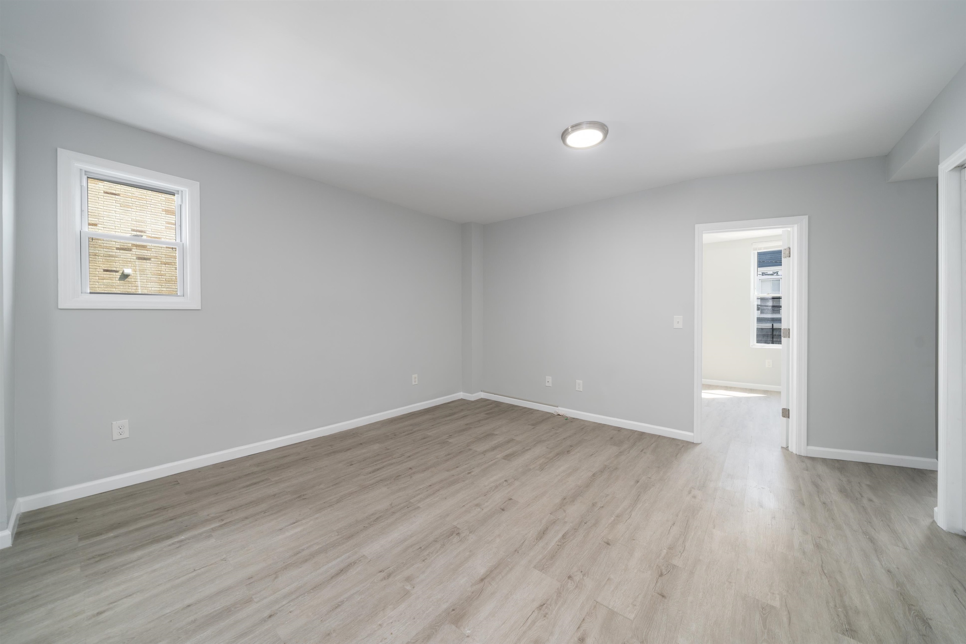 408 Monastery Place, Unit 2 Union City, NJ 07087 - Photo 9 of 21 an empty room with wooden floor and windows