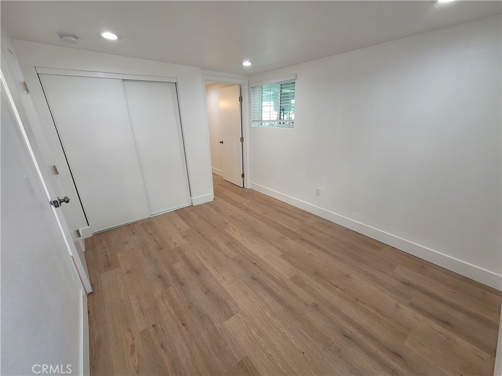 13564 4th Street, Unit 2 Yucaipa, CA 92399 - Photo 5 of 7 an empty room with wooden floor and windows