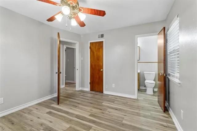 a view of a room with wooden floor and a ceiling fan