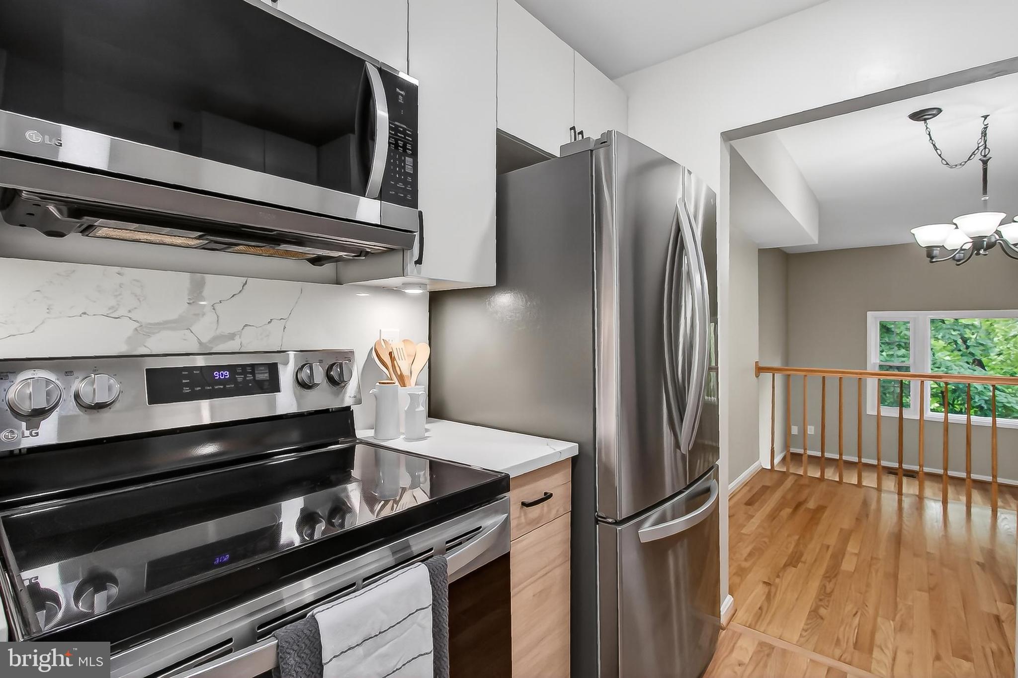 5833 Royal Ridge Drive, Unit 943 Springfield, VA 22152 - Photo 17 of 45 a kitchen with stainless steel appliances granite countertop a refrigerator and a stove top oven