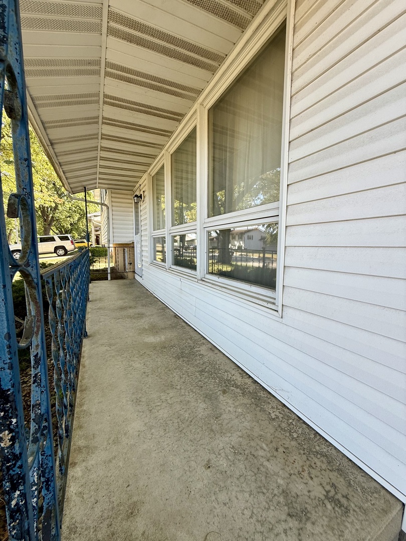 1612 Carolina Drive Rantoul, IL 61866 - Photo 2 of 18 a view of a porch with a table and chairs and floor to ceiling window