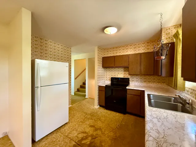 a kitchen with granite countertop a refrigerator and a sink