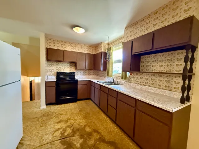 a large kitchen with a stove and a refrigerator
