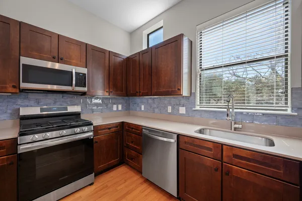 a kitchen with a sink stove and microwave