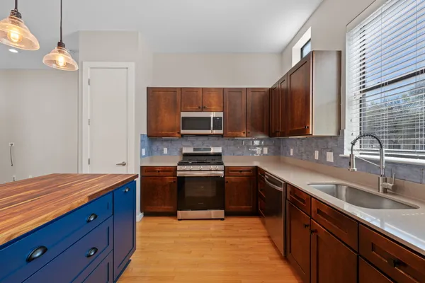 a kitchen with stainless steel appliances granite countertop a sink a stove and a refrigerator