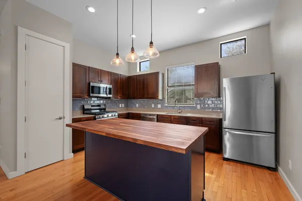 a large kitchen with stainless steel appliances granite countertop a sink refrigerator and microwave