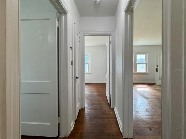 a view of a hallway with wooden floor
