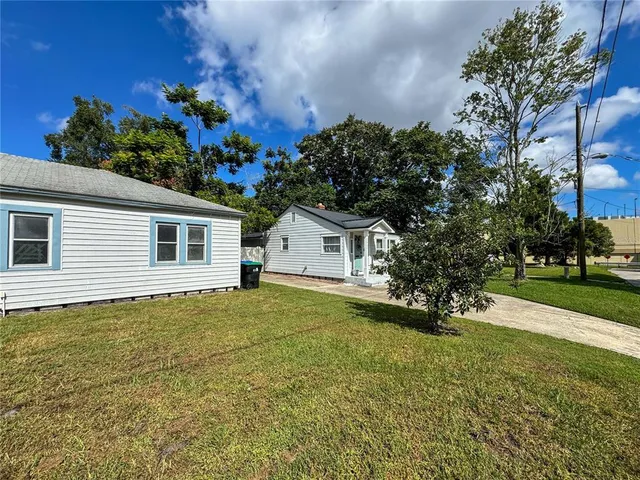 a view of a house with a yard and potted plants