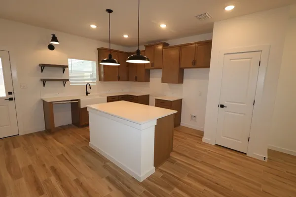 a kitchen with a sink a refrigerator and wooden floor