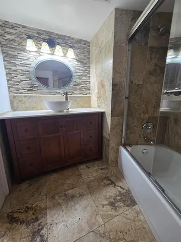 a bathroom with a tub sink and mirror