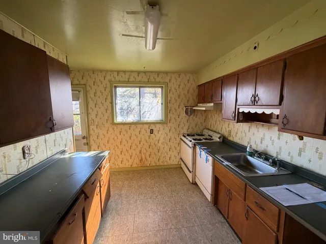 a kitchen with granite countertop a stove and a sink