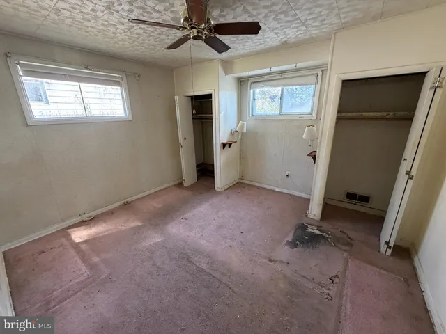 an empty room with windows and closet