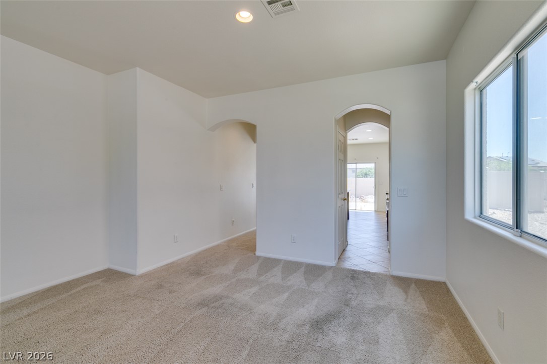 5150 Riverside Run Court North Las Vegas, NV 89081 - Photo 11 of 50 Natural light bathes this spacious room with plush carpeting and graceful arched doorways.