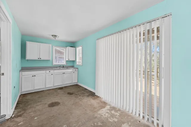 a view of an empty room with closet and a window
