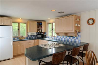 27 Nyes Point Way Centerville, MA 02632 - Photo 6 of 11 a kitchen with a dining table chairs and a refrigerator