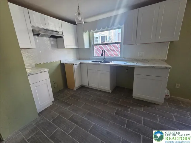 a kitchen with a sink cabinets and window