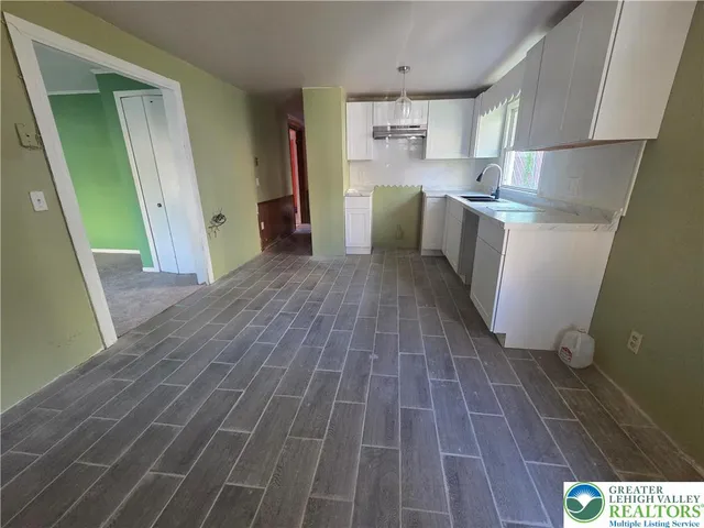 a kitchen with cabinets and wooden floor
