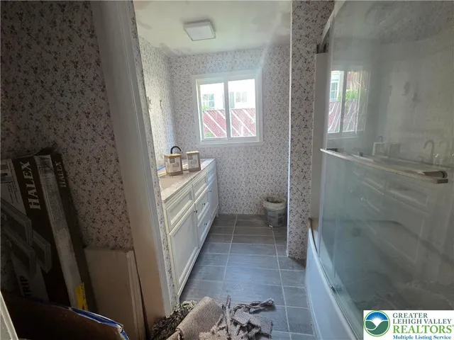 a bathroom with sink a mirror a bathtub and shower