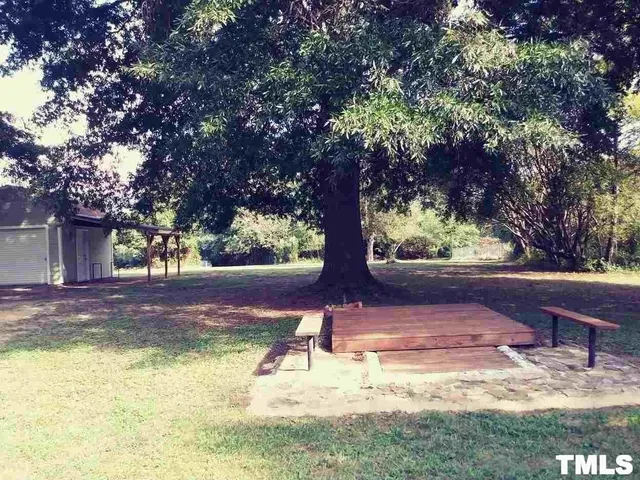 a view of yard with tree in the background
