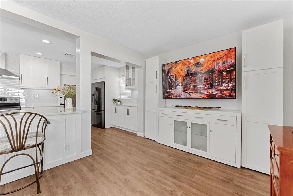 1001 Southwest 6th Avenue Boynton Beach, FL 33426 - Photo 14 of 31 a kitchen with stainless steel appliances white cabinets and wooden floor