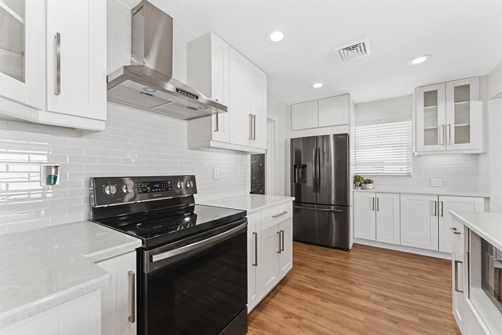 1001 Southwest 6th Avenue Boynton Beach, FL 33426 - Photo 9 of 31 a kitchen with stainless steel appliances granite countertop a refrigerator and a stove top oven