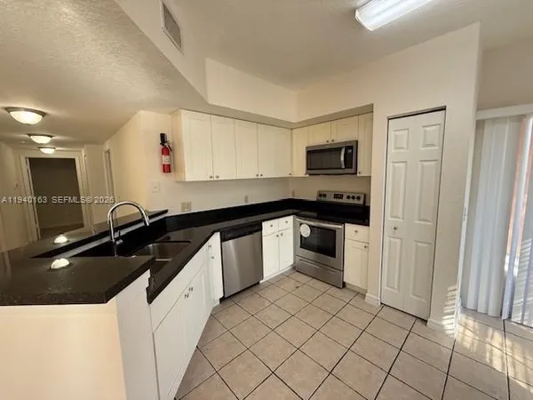 a kitchen with granite countertop a sink and a stove top oven