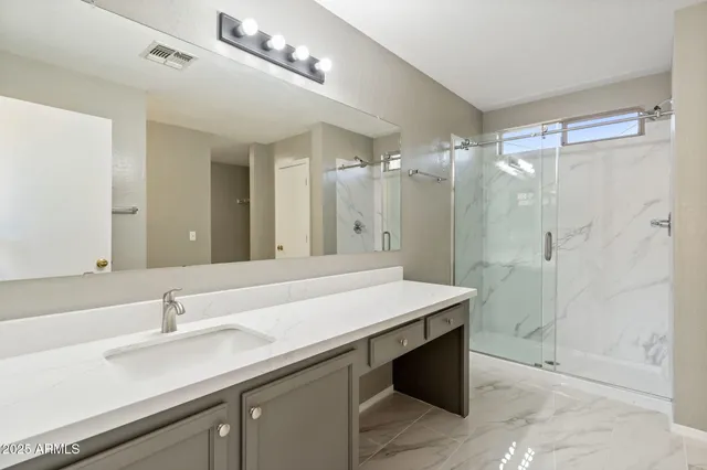 a bathroom with a sink a mirror and a shower