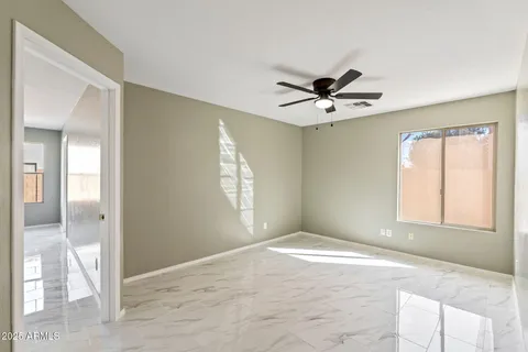 a view of a livingroom with a chandelier fan and windows