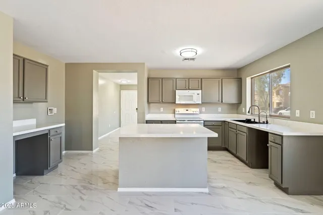 a large kitchen with kitchen island a sink stainless steel appliances and cabinets